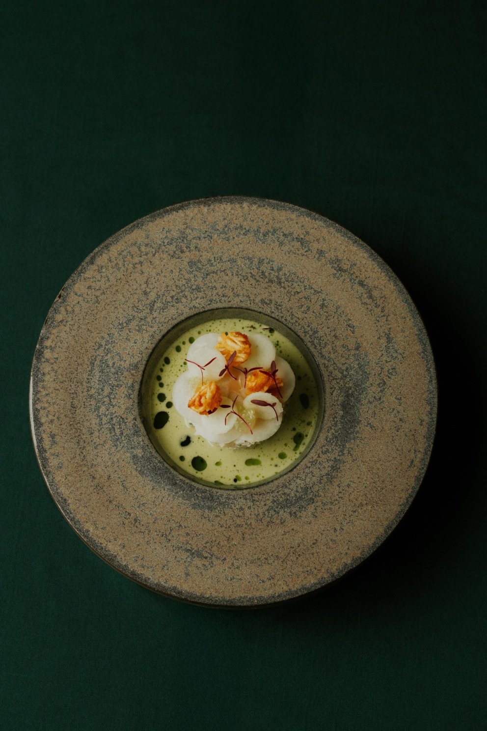 stukje gebrande witte vis, die mooi gelakt is, wordt geserveerd op een donker bruin bord